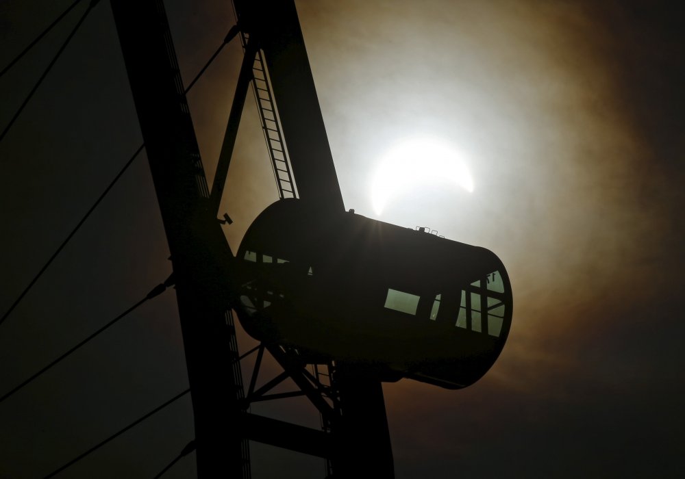 Капсула колеса обозрения на фоне частичного солнечного затмения в Сингапуре. © REUTERS