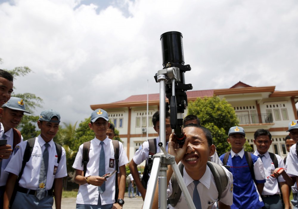 Школьники смотрят на солнце во время совместного семинара между астрономическим обществом Гонконга и Национальным институтом Индонезии по аэронавтике и исследованию космического пространства. Индонезия. © REUTERS 