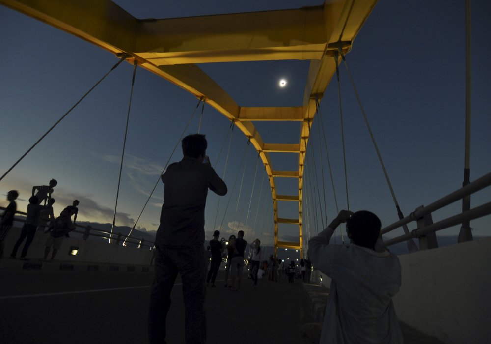 Люди наблюдают полное солнечное затмение. Индонезия. © REUTERS