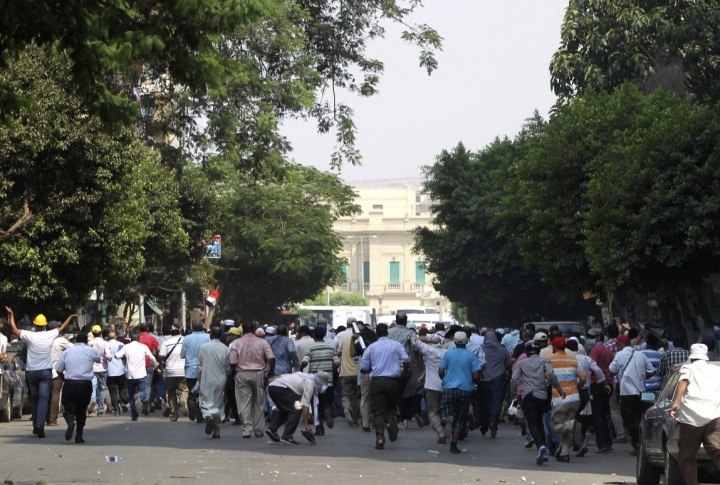 Сторонники свергнутого президента Мохаммеда Мурси бегут во время столкновений с полицией в центре Каира 13 августа 2013 года. Фото ©REUTERS