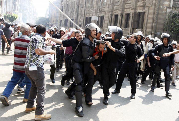 Милиция задержала сторонника Мохаммеда Мурси во время столкновений в центре Каира 13 августа 2013 года. Фото ©REUTERS