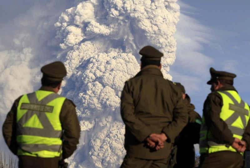 Чилийские полицейские наблюдают за извержением вулкана. ©REUTERS/Ivan Alvarado