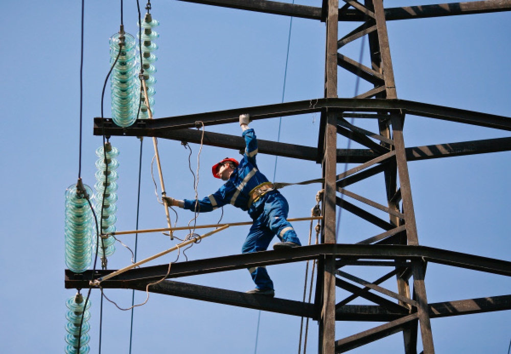 Монтажник проводит ремонт на линии электропередач. ©РИА Новости
