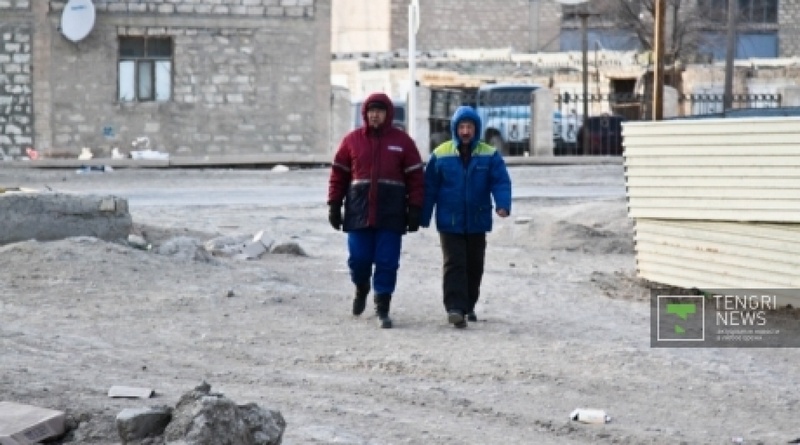 Жители Жанаозена в спецодежде "Озенмунайгаз" и "Каражанбасмунай". Фото ©Даниал Окасов