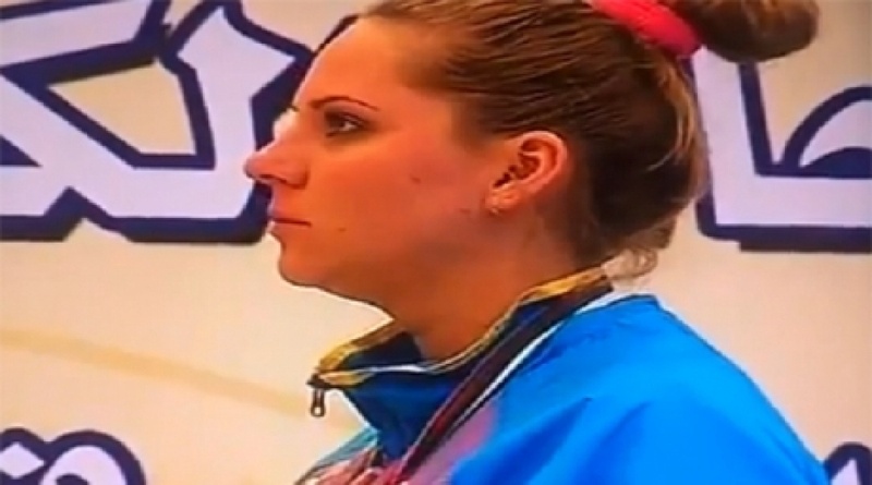 Казахстанская спортсменка Мария Дмитриенко слушает "неправильный гимн". Кадр видеоролика с Youtube