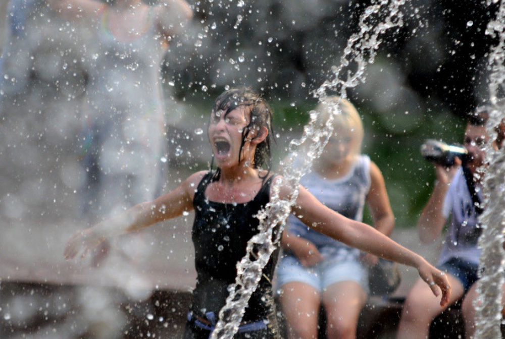 Люди спасаются от жары в городских фонтанах. Фото РИА Новости©