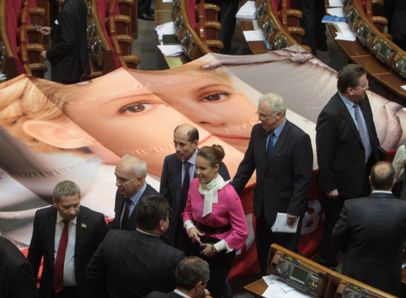 Депутаты проходят мимо плаката с изображением экс-премьера Юлии Тимошенко. Фото РИА Новости©