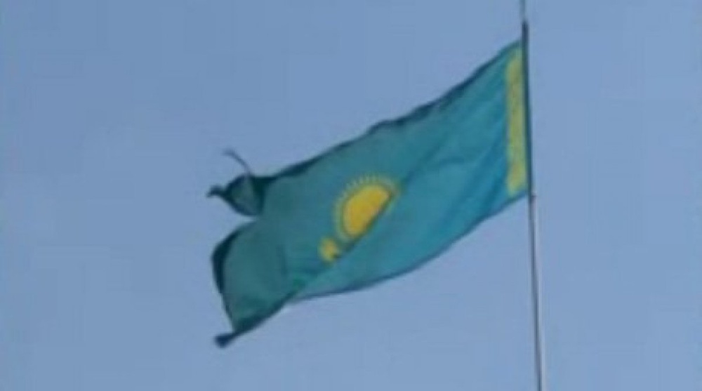 Порванный флаг на здании перинатального центра. Кадр 1tv.kz