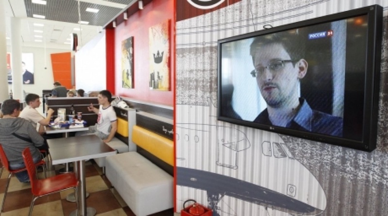 Эдвард Сноуден на экране телевизора в кафе. Фото ©REUTERS