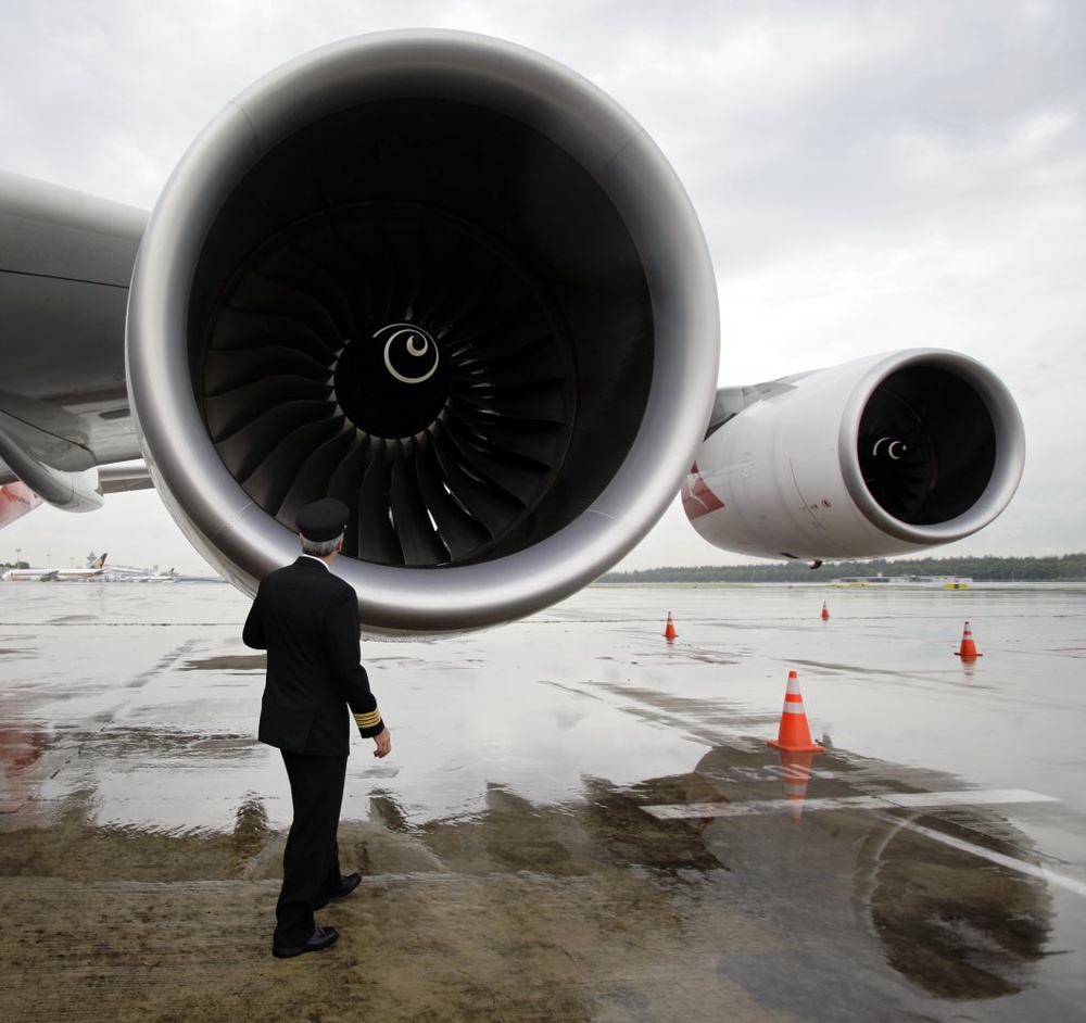 Пилот осматривает двигатели авиалайнера. Фото ©РИА Новости