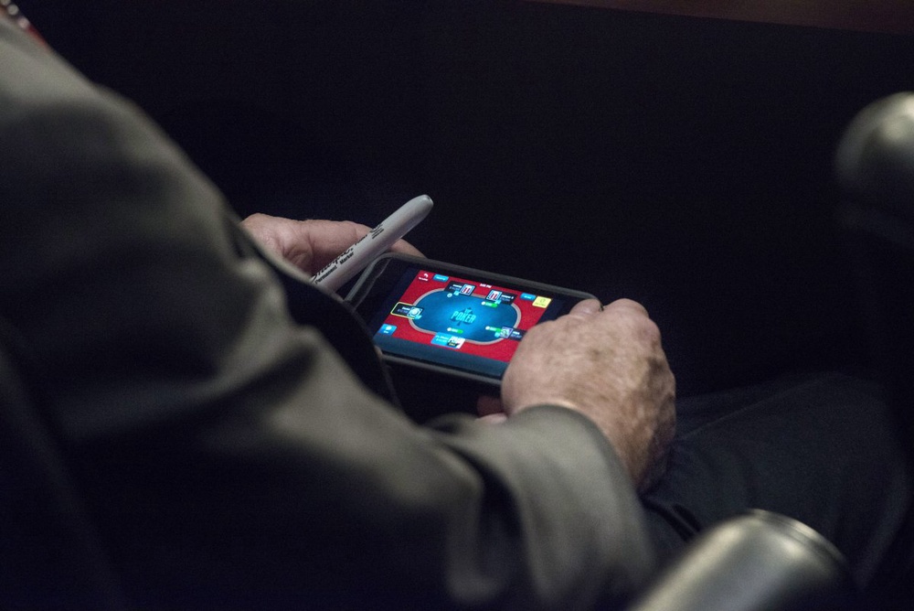 Сенатор Маккейн играет в покер на iPhone. Фото с washingtonpost.com