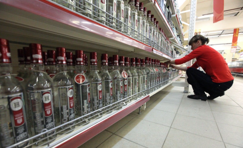 Работник магазина расставляет бутылки с водкой. Фото ©РИА Новости