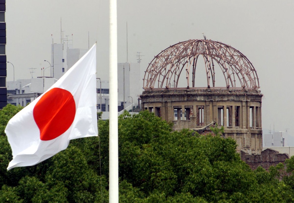 Японский флаг на фоне мемориала жертв ядерной бомбардировки в Хиросиме. ©REUTERS