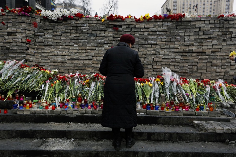 Женщина у превращенной в мемориал баррикады в Киеве. ©REUTERS