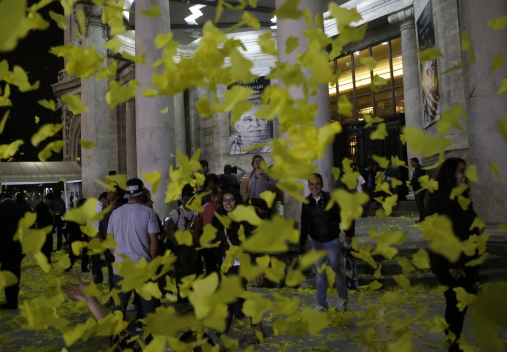 Люди стоят у Дворца изящных искусств в окружении желтых бумажных бабочек после прощания с Габриэлем Гарсиа Маркесом. ©REUTERS