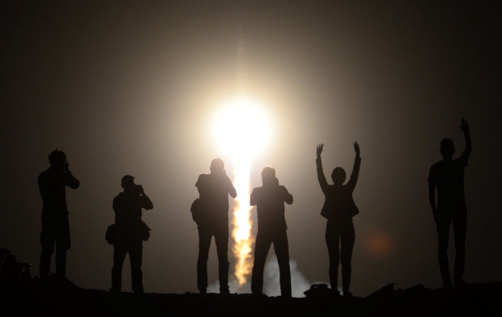 Люди наблюдают за пуском ракеты с космодрома "Байконур". © РИА Новости