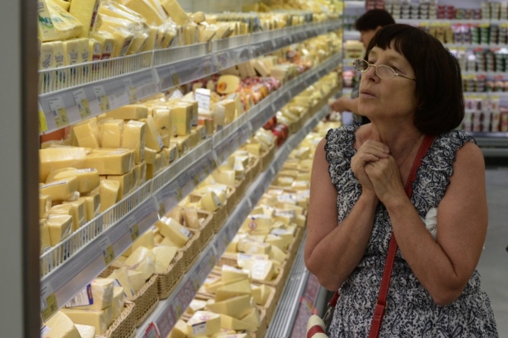 Женщина у прилавка с сырами в гипермаркете Новосибирска. ©РИА Новости