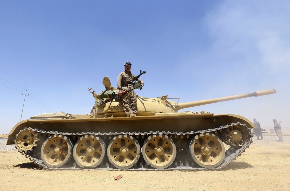 Курдский повстанец стоит на танке во время операции против боевиков исламского государства на окраине провинции Ниневия. ©REUTERS