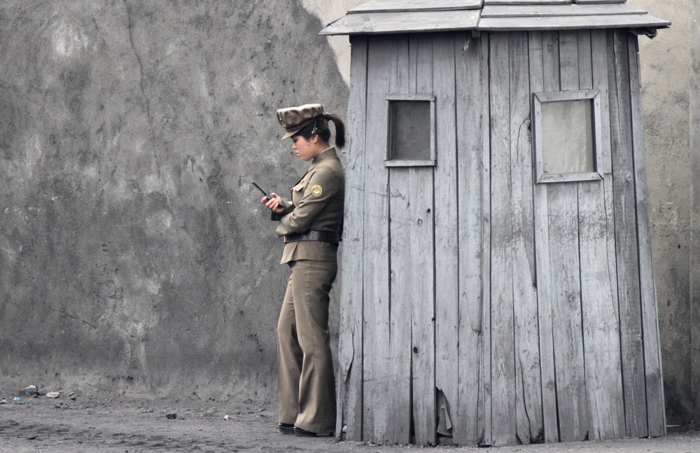 Северокорейская военнослужащая с мобильным телефоном. ©REUTERS