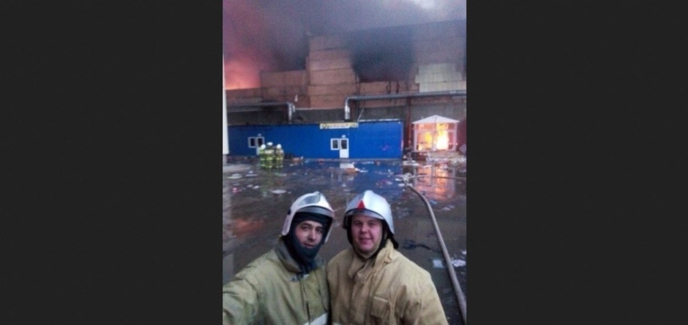 Сэлфи пожарных на фоне горящего ТРЦ. Фото из социальных сетей.