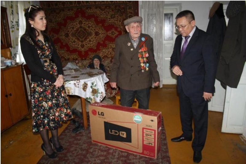 Представители ДГД по Жамбылской области дарят ветерану подарки. Фото предоставлено пресс-службой Комитета государственных доходов МФ РК.