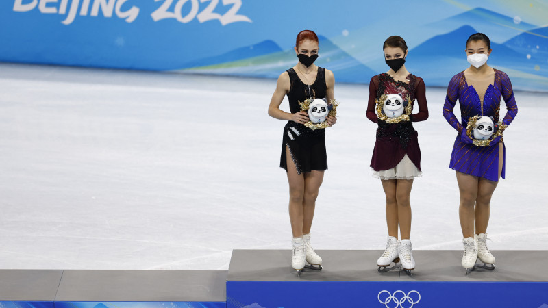 Александра Трусова, Анна Щербакова и Каори Сакамото на пьедестале после выступления в женском одиночном катании на зимних Олимпийских играх 2022 года в Пекине. © Reuters