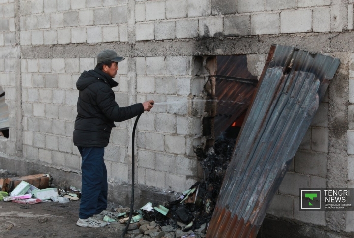 Продавцы разбивали забор и старались потушить свой контейнер. 
 ©Владимир Прокопенко