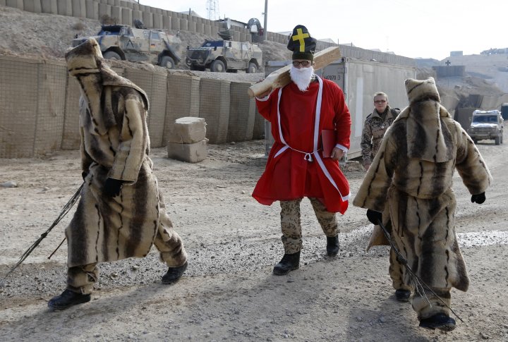 Солдат в роли Санты идет раздавать подарки в Афганистане  Baghlan, Afghanistan фото © REUTERS Fabrizio Bensch