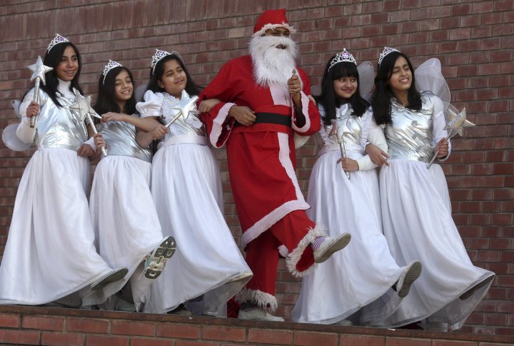 Студент, наряженный в Санта Клауса, танцует с другими студентами во время празднования Рождества. Chandigarh, India фото ©REUTERS Ajay Verma 