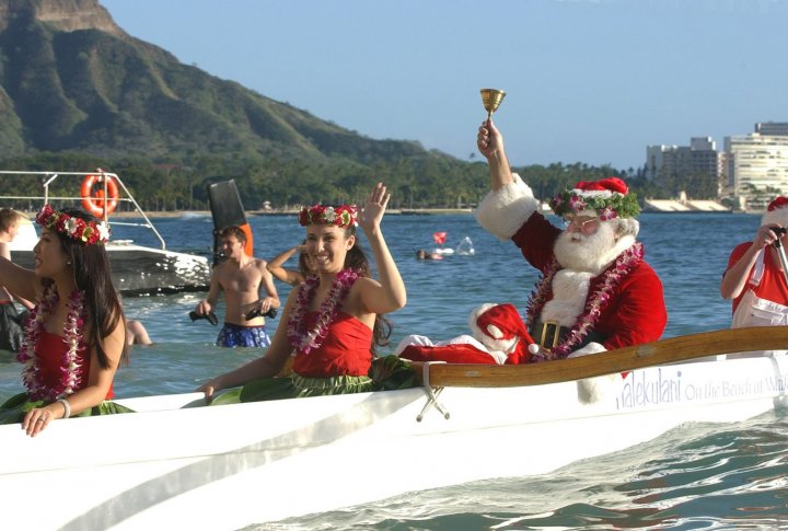 Санта Клаус  прибывает на Вайкики-Бич в каноэ без саней и оленей в Гонолулу, Гавайи в канун Рождества. Honolulu фото ©REUTERS Lucy Pemoni