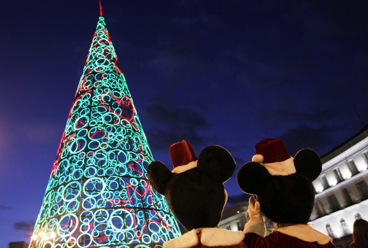Два человека, одетые в костюмы Микки-Мауса, стоят рядом с новогодней елкой. Madrid, Spain фото ©REUTERS Susana Vera