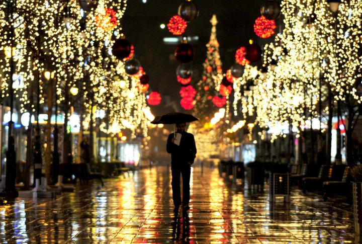 Мужчина идет по освещенной рождественскими огнями улице. Skopje, Macedonia фото © REUTERS Ognen Teofilovski