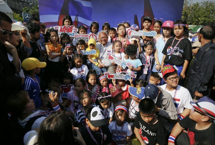 Лидер протестующих Сутеп Таугсубан в окружении детей и своих сторонников у монумента Победы в Бангкоке. ©REUTERS
