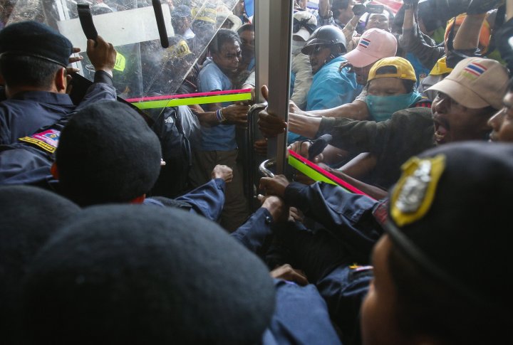 Протестующие сражаются с полицией во время митинга на стадионе в Бангкоке. ©REUTERS