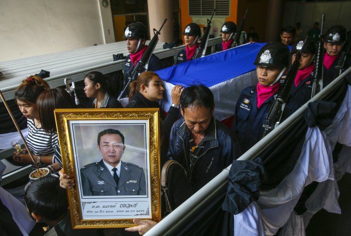 Родственники и скорбящие направляются к храму для церемонии похорон полицейского, который умер после ранения во время столкновений между участниками антиправительственных демонстраций и полиции, в полицейском госпитале в Бангкоке. ©REUTERS