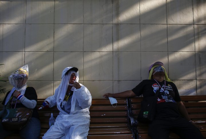Демонстранты закрывают лица, спасаясь от слезоточивого газа. ©REUTERS