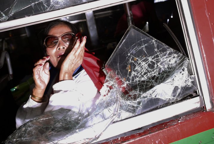 Испуганная женщина в автобусе во время столкновений полиции и демонстрантов.  ©REUTERS