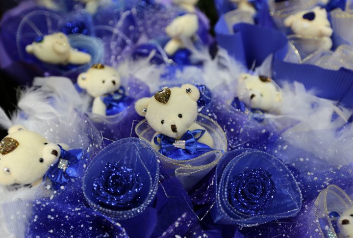 Игрушечные в букете с голубыми розами, для продажи в День святого Валентина на рынке в Пекине. ©REUTERS