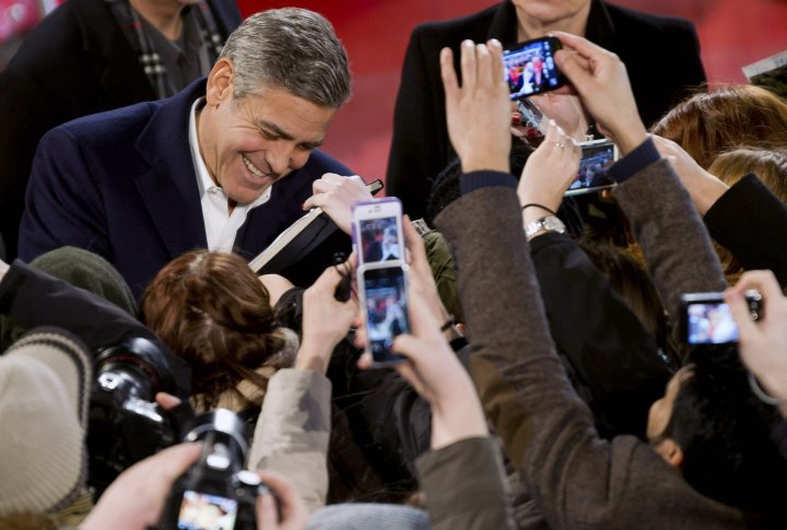 Джордж Клуни раздает автографы на красной дорожке Берлинале. REUTERS©