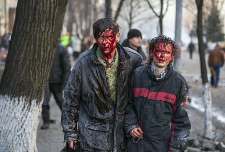 Раненые протестующие после столкновений с полицией в центре Киева 18 февраля 2014 года. ©REUTERS