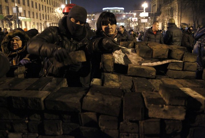 Антиправительственные протестующие строят баррикаду из тротуарной плитки в центре Киева 20 февраля 2014 года. ©REUTERS