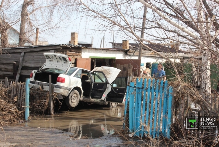 Житель этого дома не успел спасти свое имущество. Автомобиль полностью затопило водой. Прибывшая вода закинула его на ограждение участка.