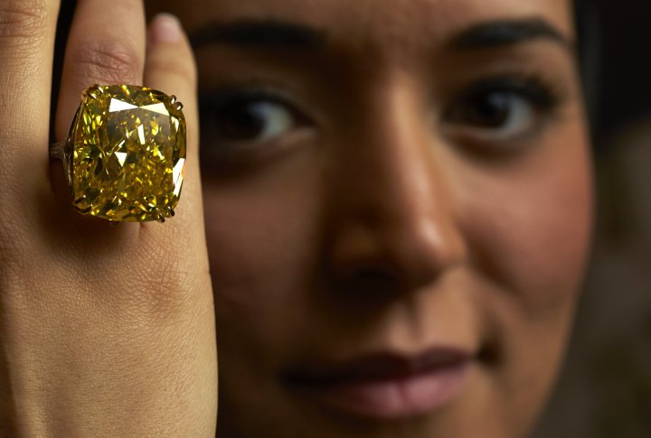 Модель демонстрирует кольцо с желтым бриллиантом, весом в 100,09 карата во время аукциона Sotheby's в Женеве 7 мая 2014 года. ©REUTERS
