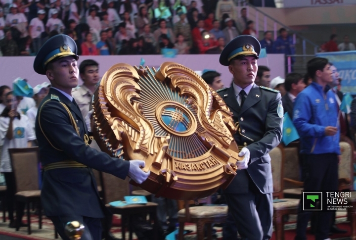 Гвардейцы торжественно выносят Герб Республики Казахстан.