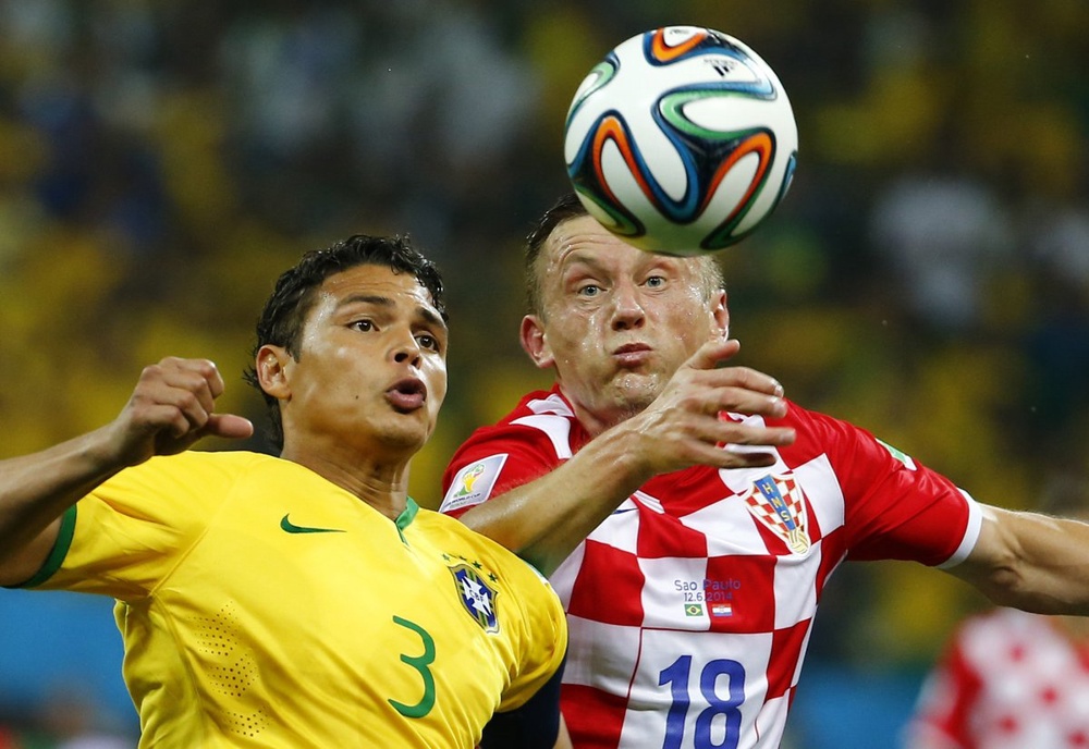 Бразилец Тиаго Силва и игрок сборной Хорватии Ивица Олич в борьбе за мяч. ©REUTERS