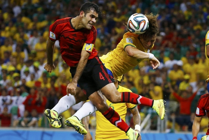 Игроки сборной Мексики Рафаэль Маркес (слева) и сборной Бразилии Давид Луис в борьбе за мяч. ©REUTERS