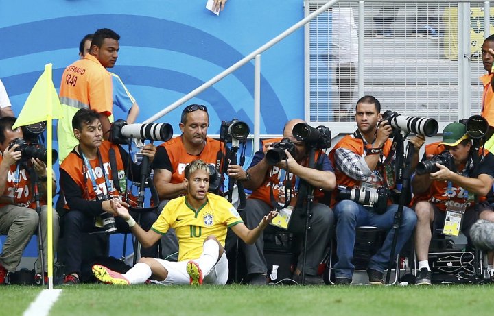 Игрок сборной Бразилии Неймар после фола камерунца Аллана  Ниома. ©REUTERS