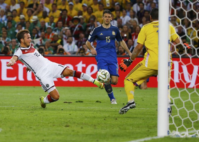Игрок команды Германии Марио Гетце забивает решающий мяч в ворота сборной Аргентины в дополнительное время. ©REUTERS