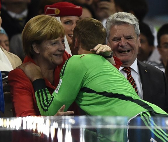Вратарь сборной Германии Мануэль Нойер получает поздравления от канцлера Ангелы Меркель и президента Йоахима Гаука (справа) после матча Германиии с Аргентиной на стадионе "Маракана" в Рио-де-Жанейро 13 июля 2014 года. ©REUTERS