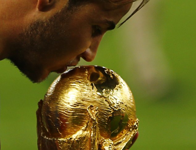 Игрок команды Германии Марио Гетце целует Кубок Мира по футболу 2014 года. ©REUTERS